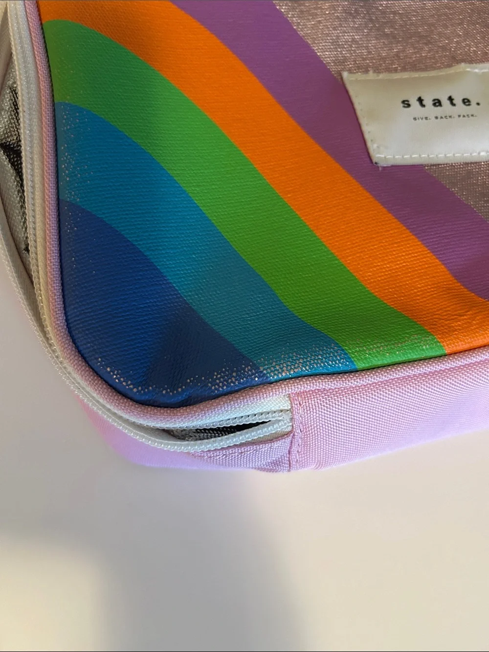 STATE Metallic Pink lunch box with Rainbow Accent with some wear .